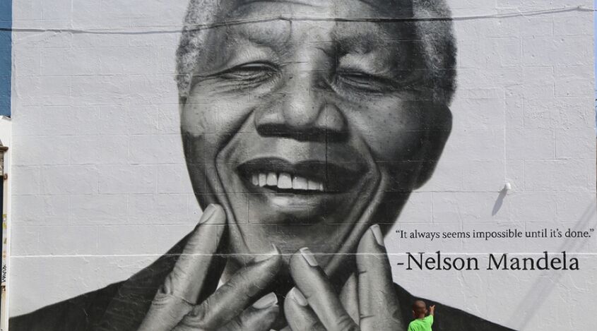 Un niño señala un poster de Mandela