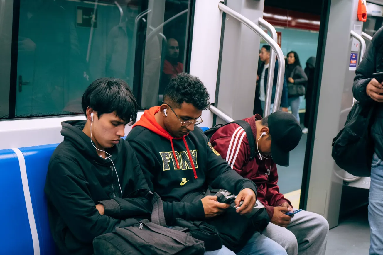 Tres hombres cansados viajan en el metro de Quito Tres hombres cansados viajan en el metro de Quito