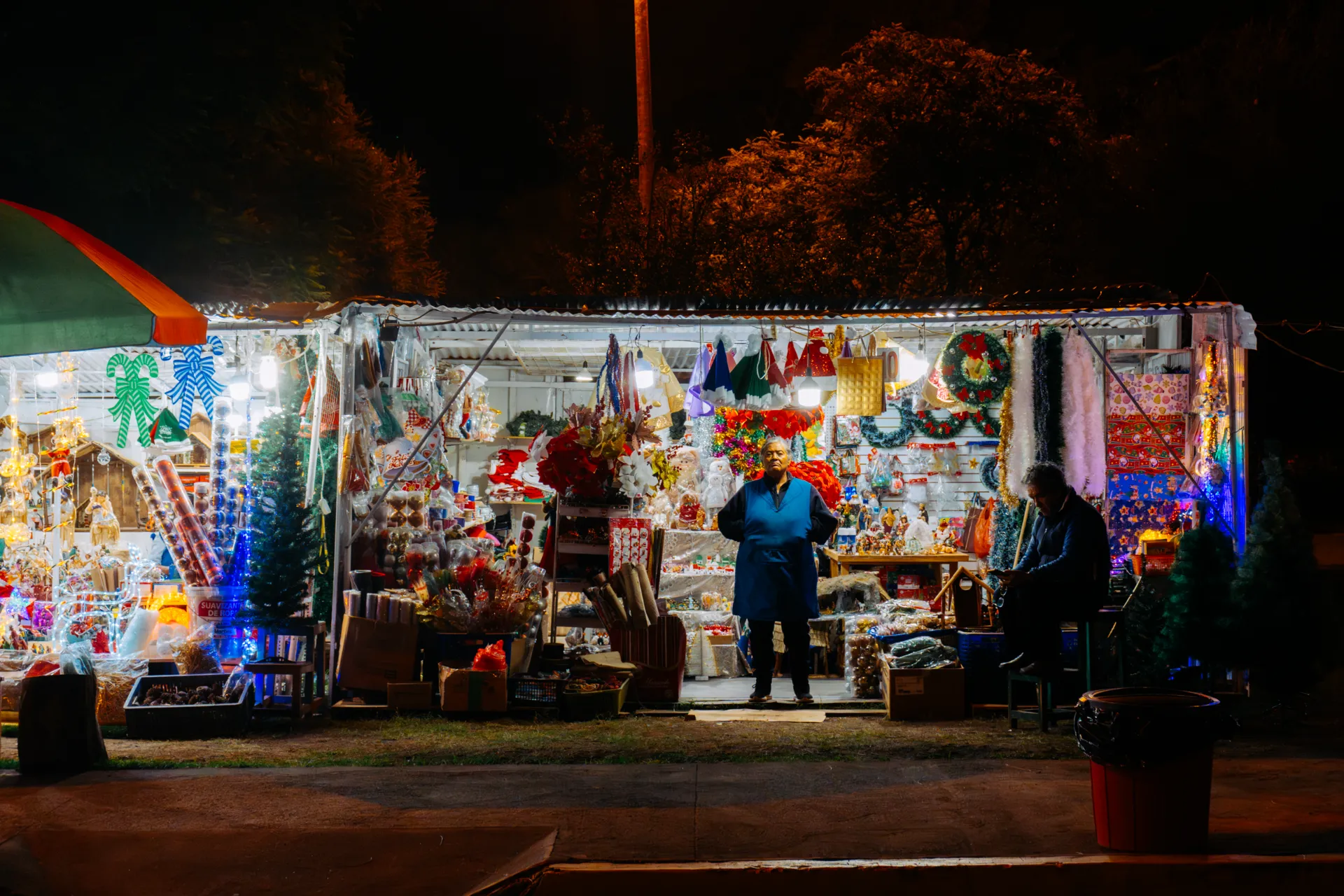 dos señores atienden en uno de los puestitos navideños de un parqueo en La Carolina dos señores atienden en uno de los puestitos navideños de un parqueo en La Carolina