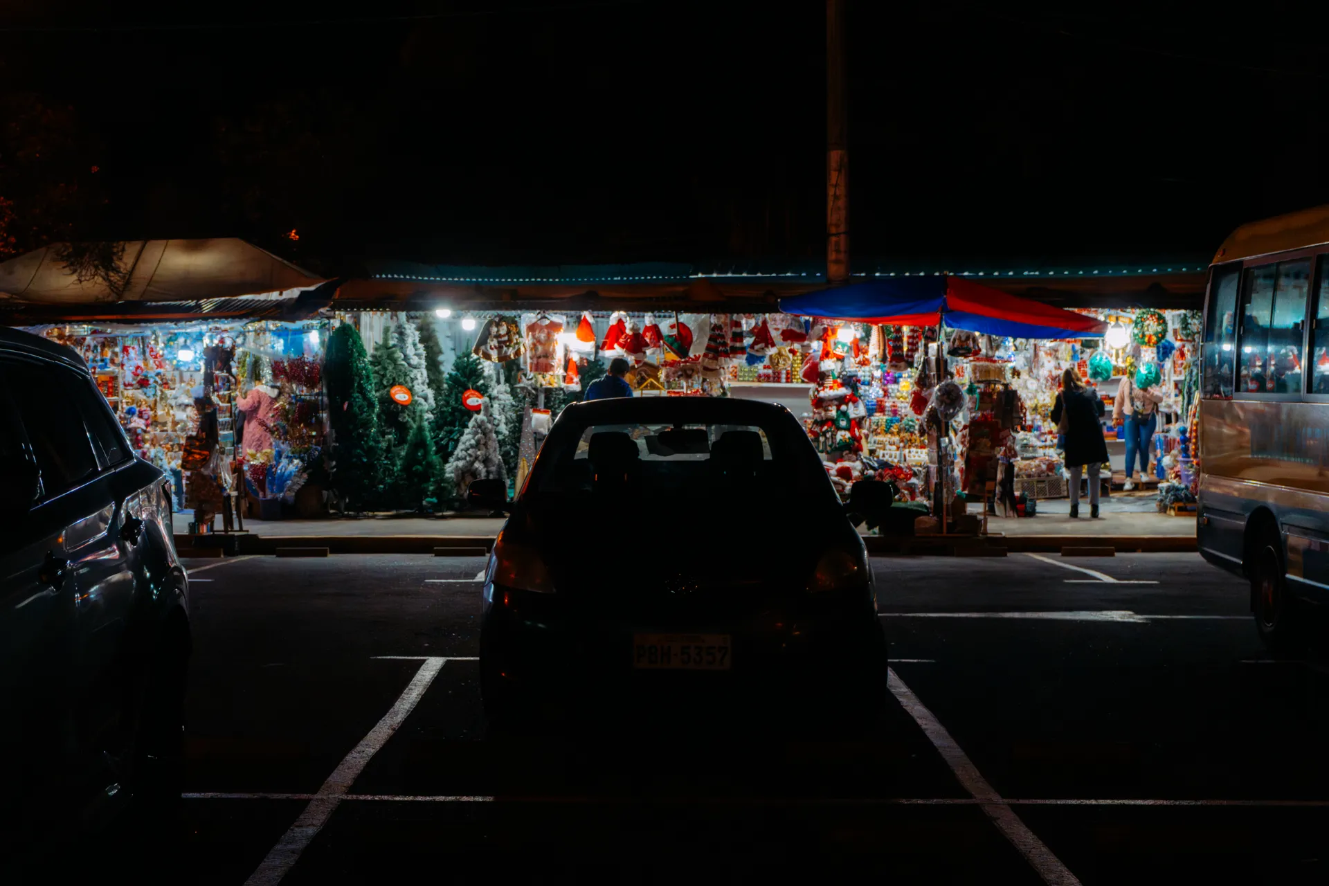 Carros y buses estacionados frente a los puestos de Navidad en Quito Carros y buses estacionados frente a los puestos de Navidad en Quito