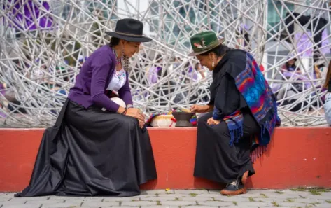 dos mujeres se preparan antes de la marcha del 8M en Quito